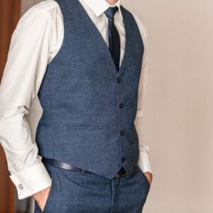 prikaz momka plavim pantalonama, plavom prsluku i beloj košulji